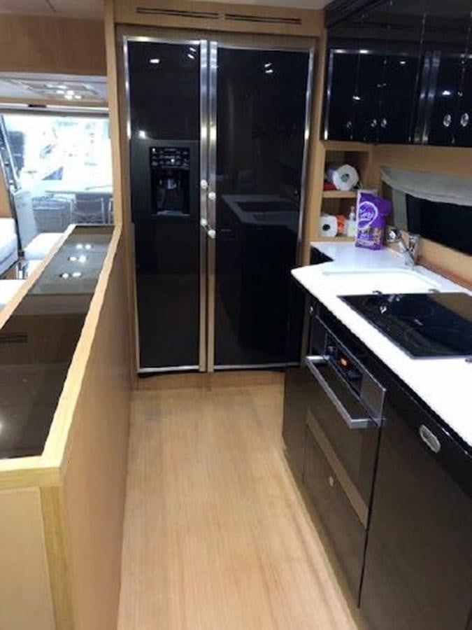 a kitchen with black cabinets aboard 2013 RIVA 75 VENERE SUPER Yacht for Sale