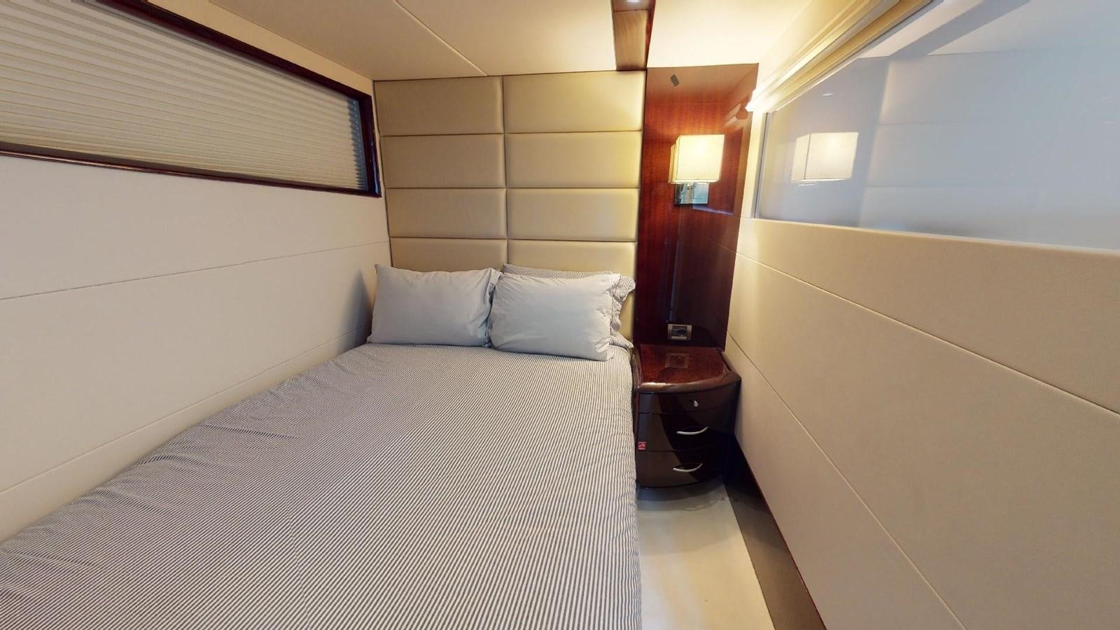 a bed with a white sheet and a lamp on it aboard MOJO Yacht for Sale