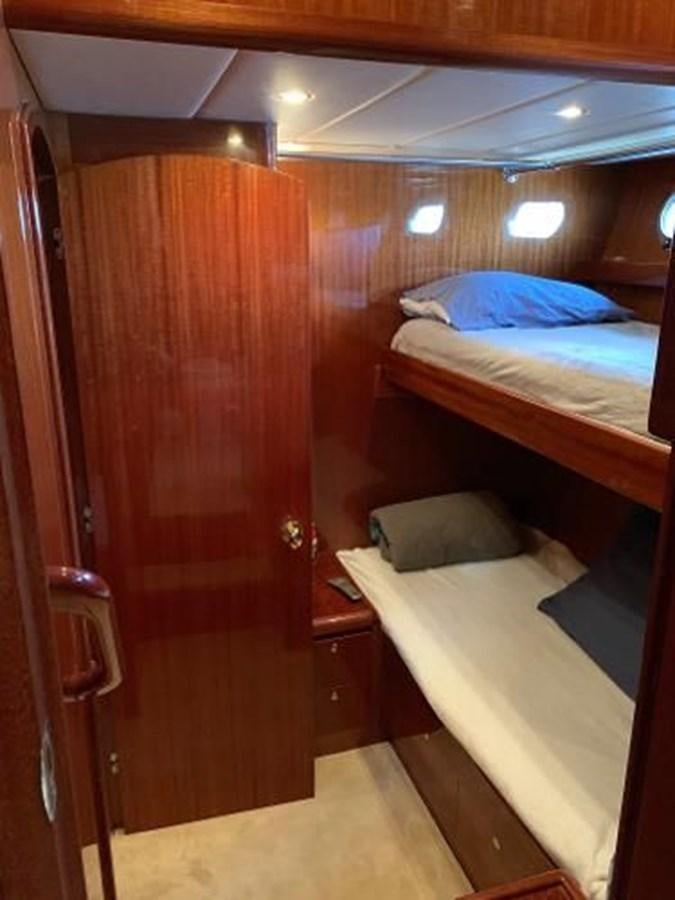 a room with a bed and a wood door aboard TAKEN TIME II Yacht for Sale