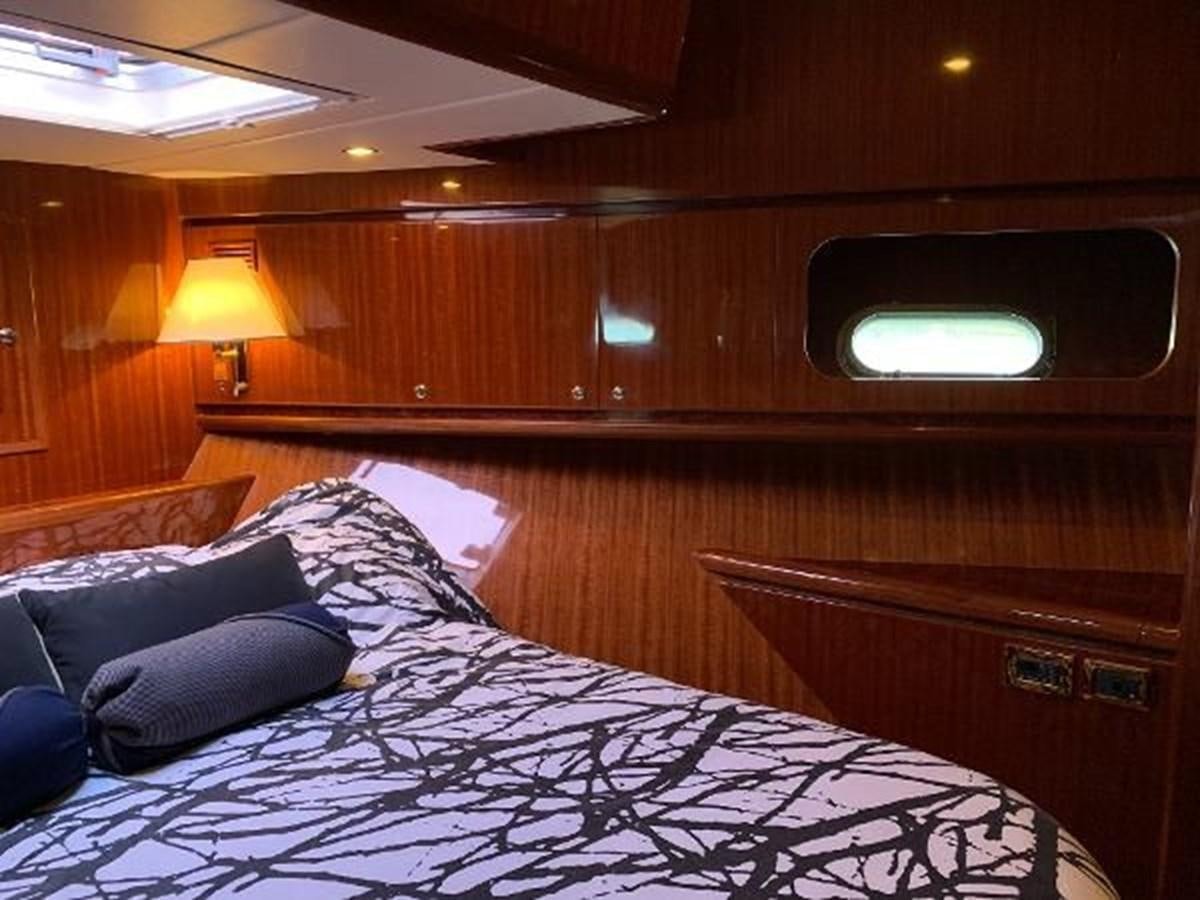 a bed with a black and white comforter and a wooden wall aboard TAKEN TIME II Yacht for Sale