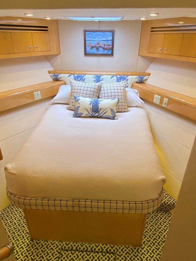 a bed with a blue and white pillow on it aboard LUISA Yacht for Sale