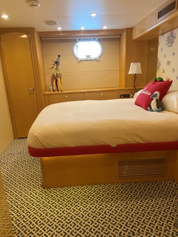 a bed with a red and yellow pillow on it aboard LUISA Yacht for Sale