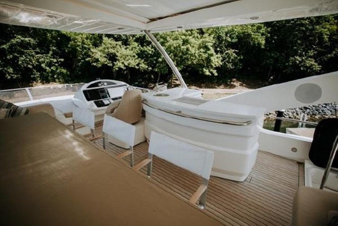 a deck with a white chair and a white table and chairs aboard ASTUR Yacht for Sale