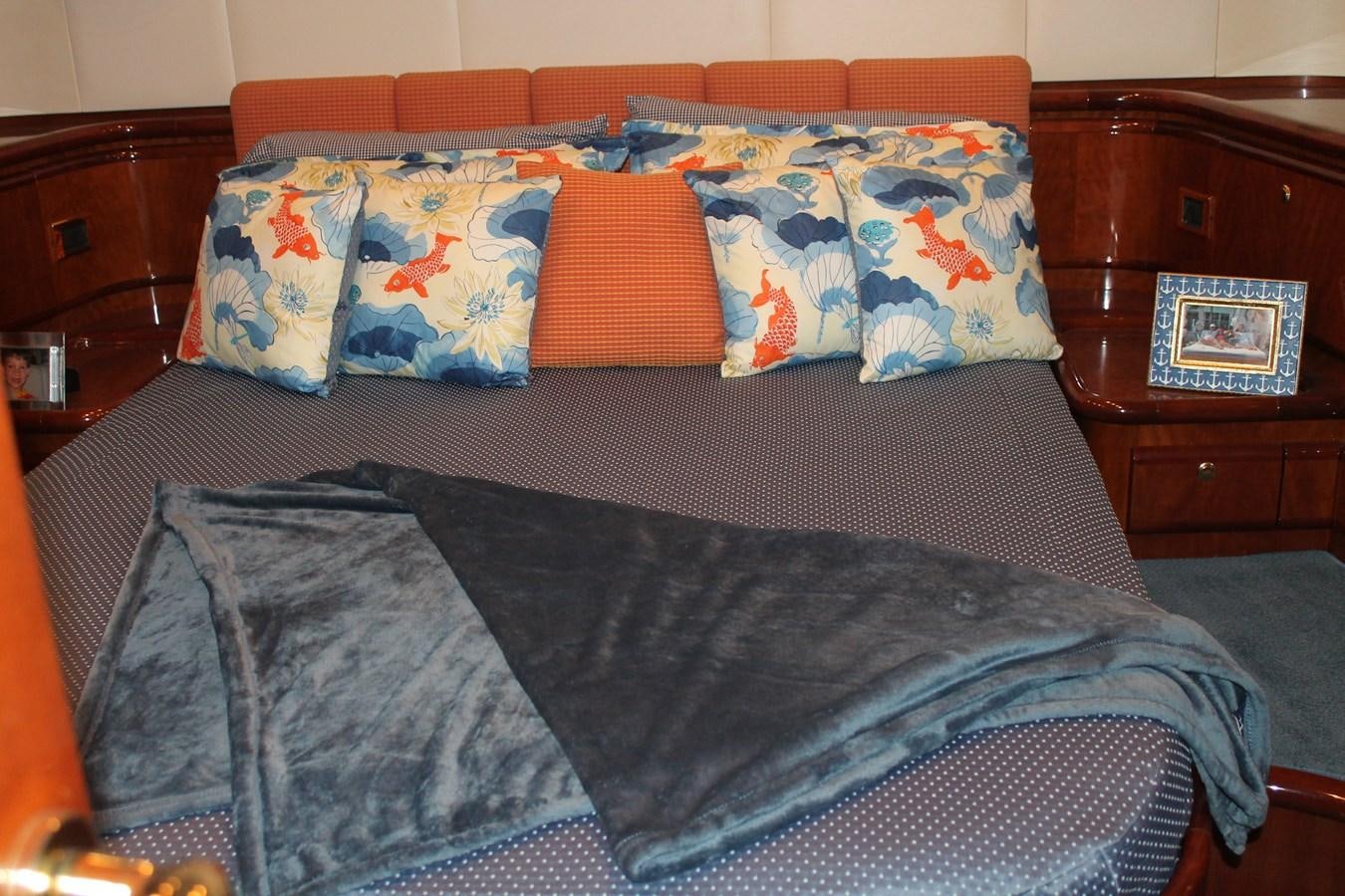 a bed with a black comforter and colorful pillows aboard MAGNIFICA Yacht for Sale