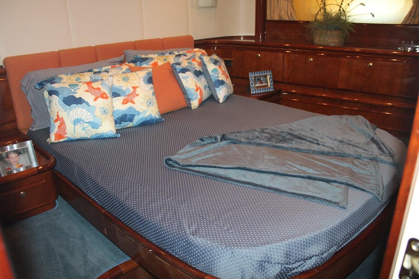 a bed with a blue and orange pillow aboard MAGNIFICA Yacht for Sale
