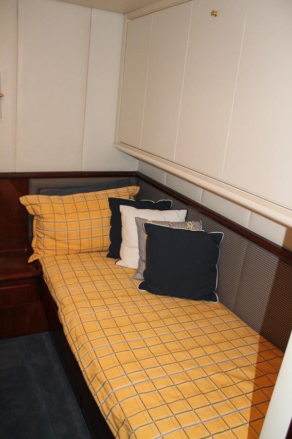 a bed with a blue and yellow blanket aboard MAGNIFICA Yacht for Sale