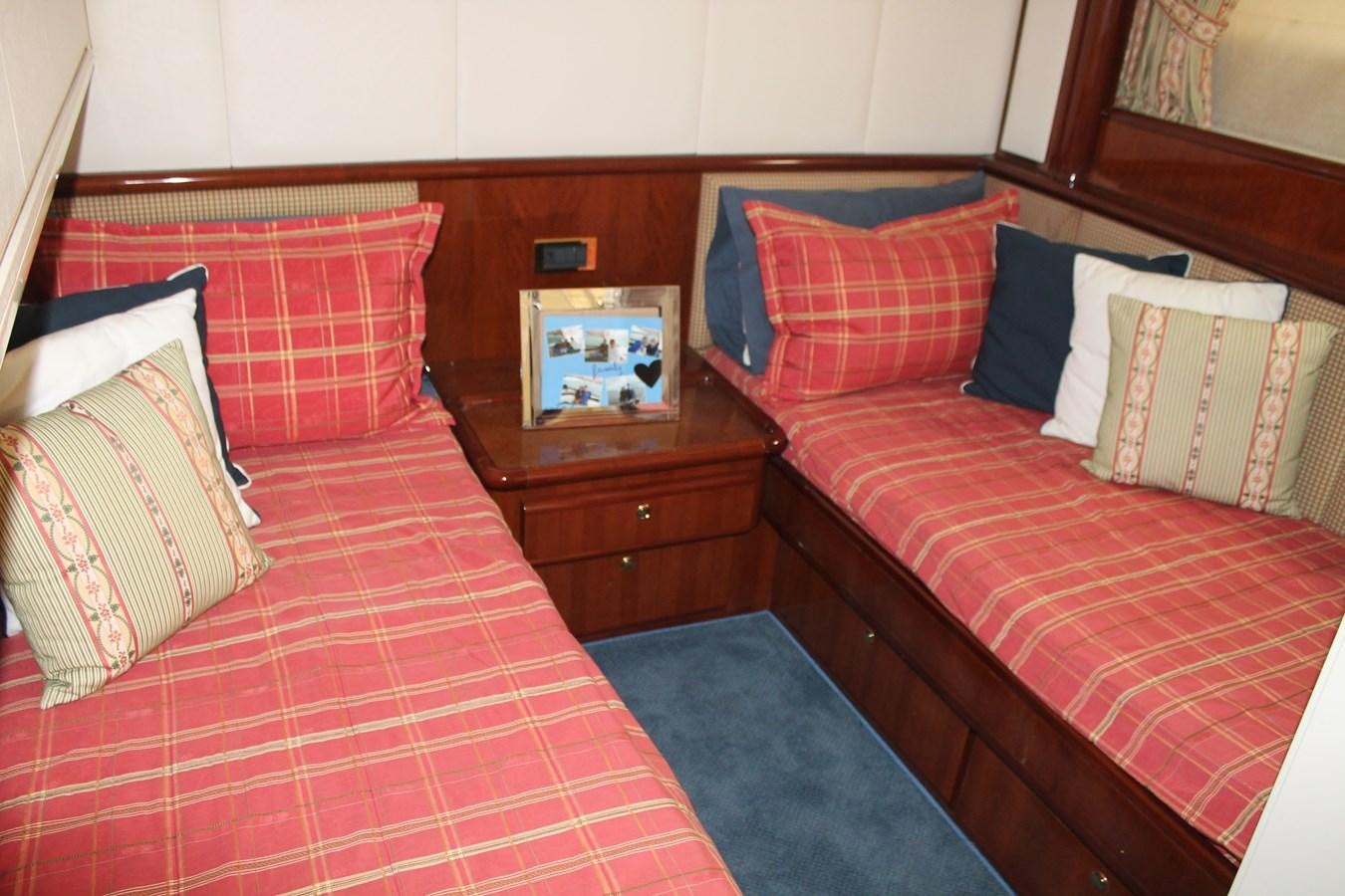 a bed with red sheets and pillows aboard MAGNIFICA Yacht for Sale