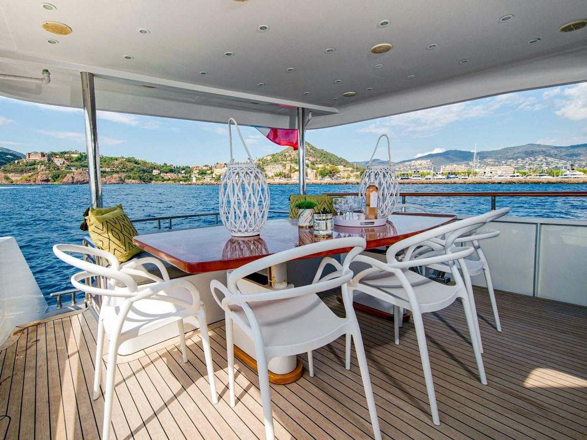 a table and chairs on a deck overlooking a body of water aboard CASPA Yacht for Sale