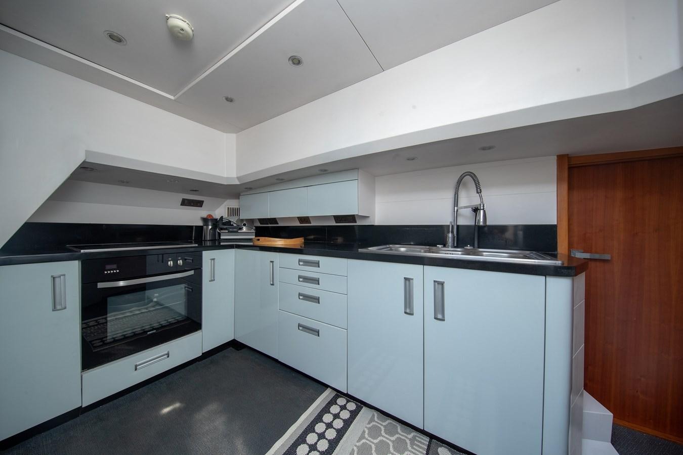 a kitchen with white cabinets aboard CASPA Yacht for Sale