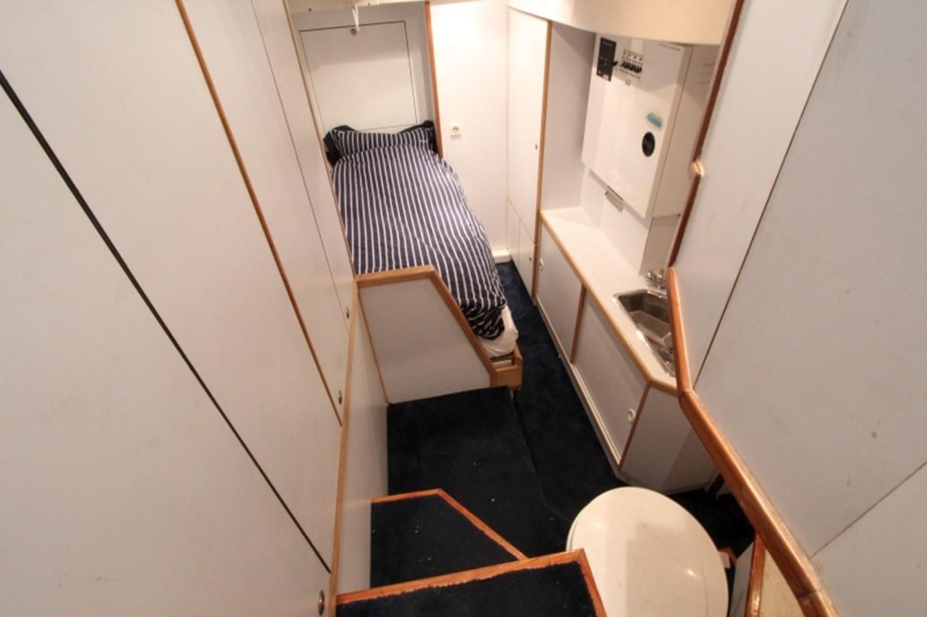a hallway with a bed and a chair aboard THE RIVER Yacht for Sale