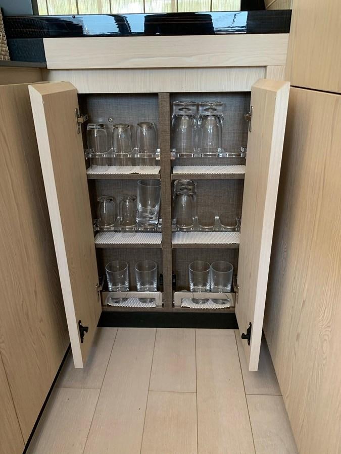 a cabinet with glasses and a glass on it aboard AMALFI Yacht for Sale