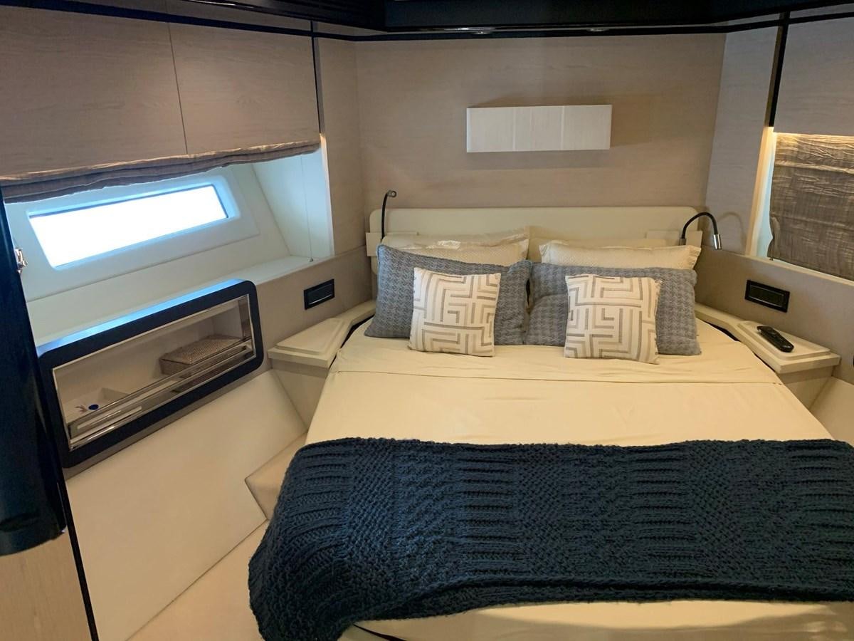 a bed with pillows and a television aboard AMALFI Yacht for Sale