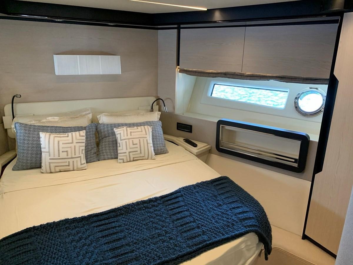 a bed with a television on the wall aboard AMALFI Yacht for Sale