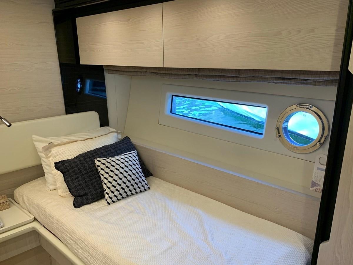 a bed with a round mirror above it aboard AMALFI Yacht for Sale
