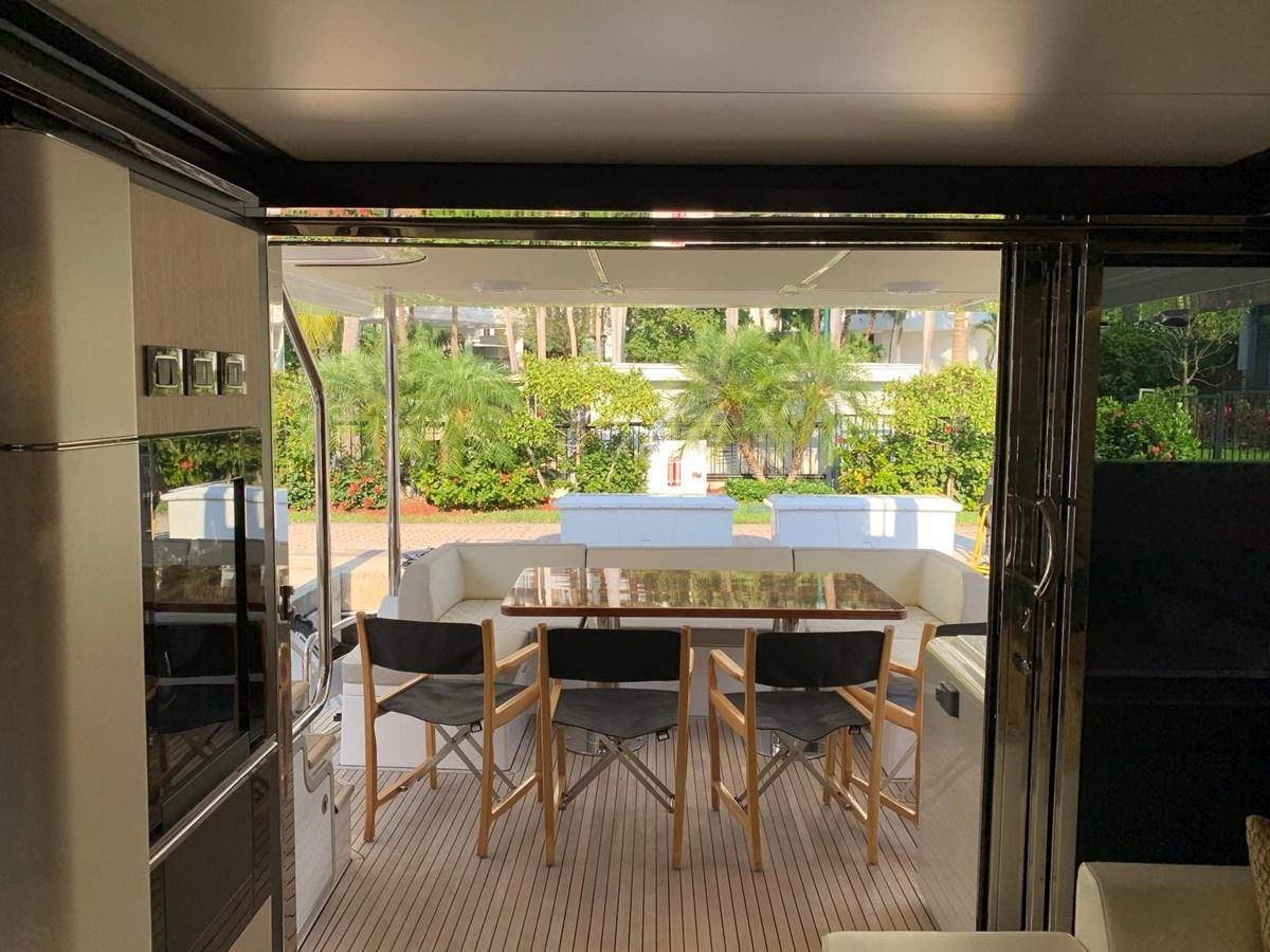 a dining table and chairs in a room with a view of the trees aboard AMALFI Yacht for Sale