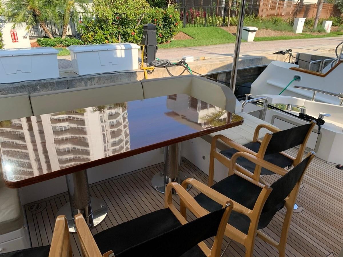 a deck with a table and chairs aboard AMALFI Yacht for Sale