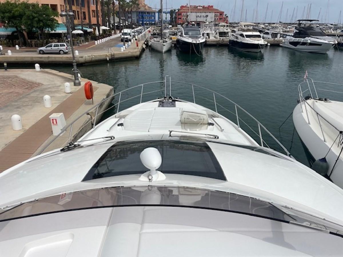 a white boat in a harbor aboard LONG WAY ROUND Yacht for Sale