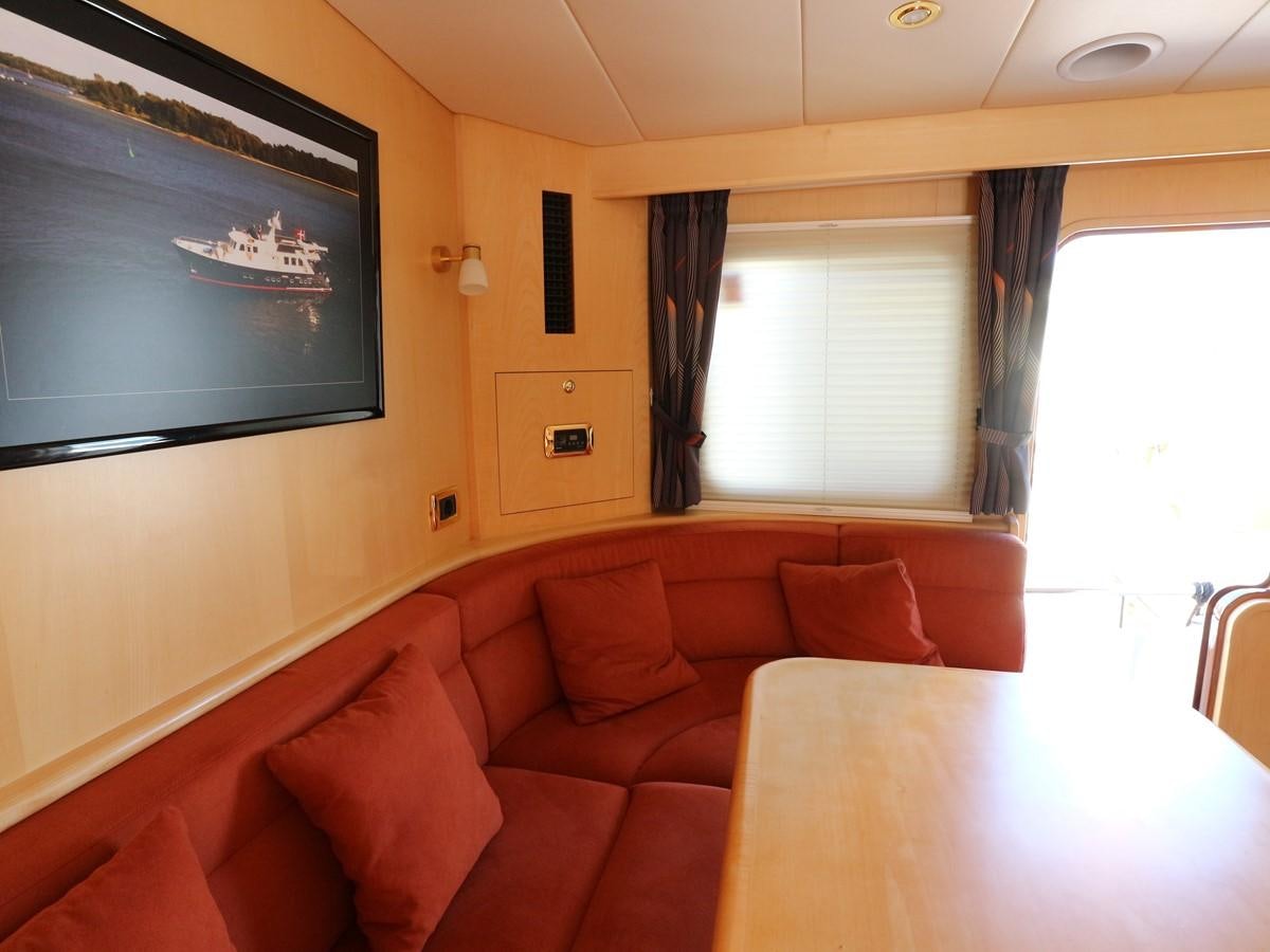 a living room with a tv on the wall aboard Polar Princess Yacht for Sale