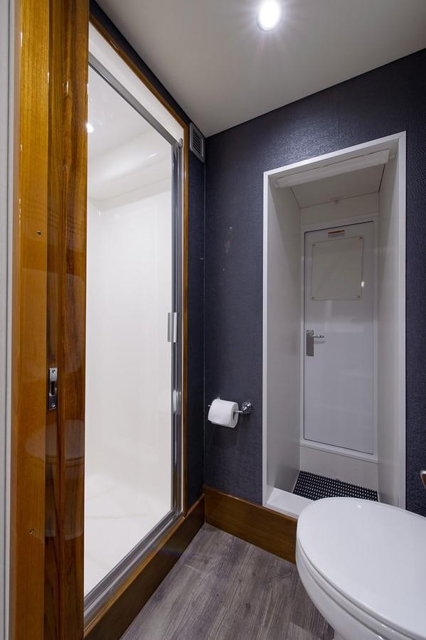 a bathroom with a toilet and a door aboard NOTORIOUS Yacht for Sale