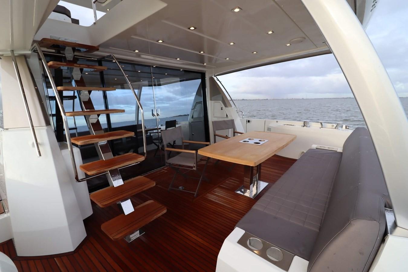 a room with a table and chairs aboard PRESTIGE 680 FLY Yacht for Sale