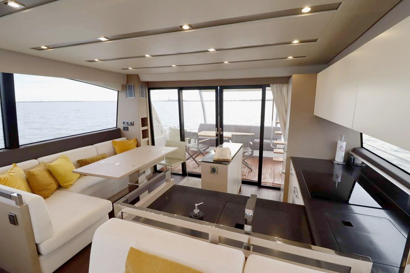 a room with a large window and a table with chairs aboard PRESTIGE 680 FLY Yacht for Sale