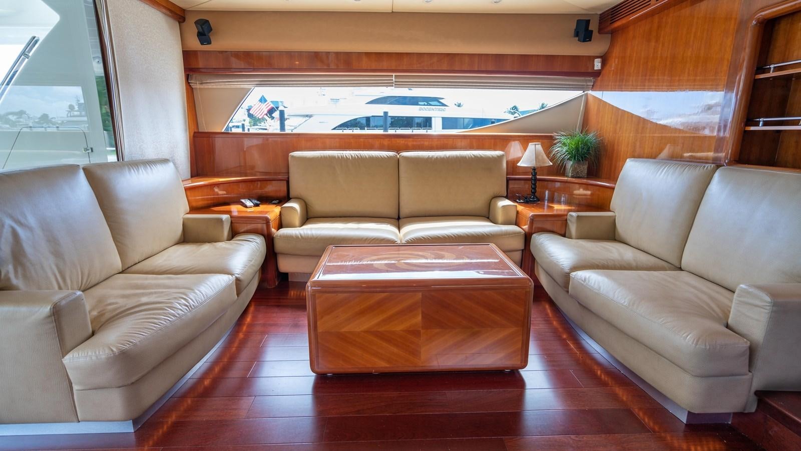 a living room with a table and couches aboard FOOLISH PLEASURE Yacht for Sale