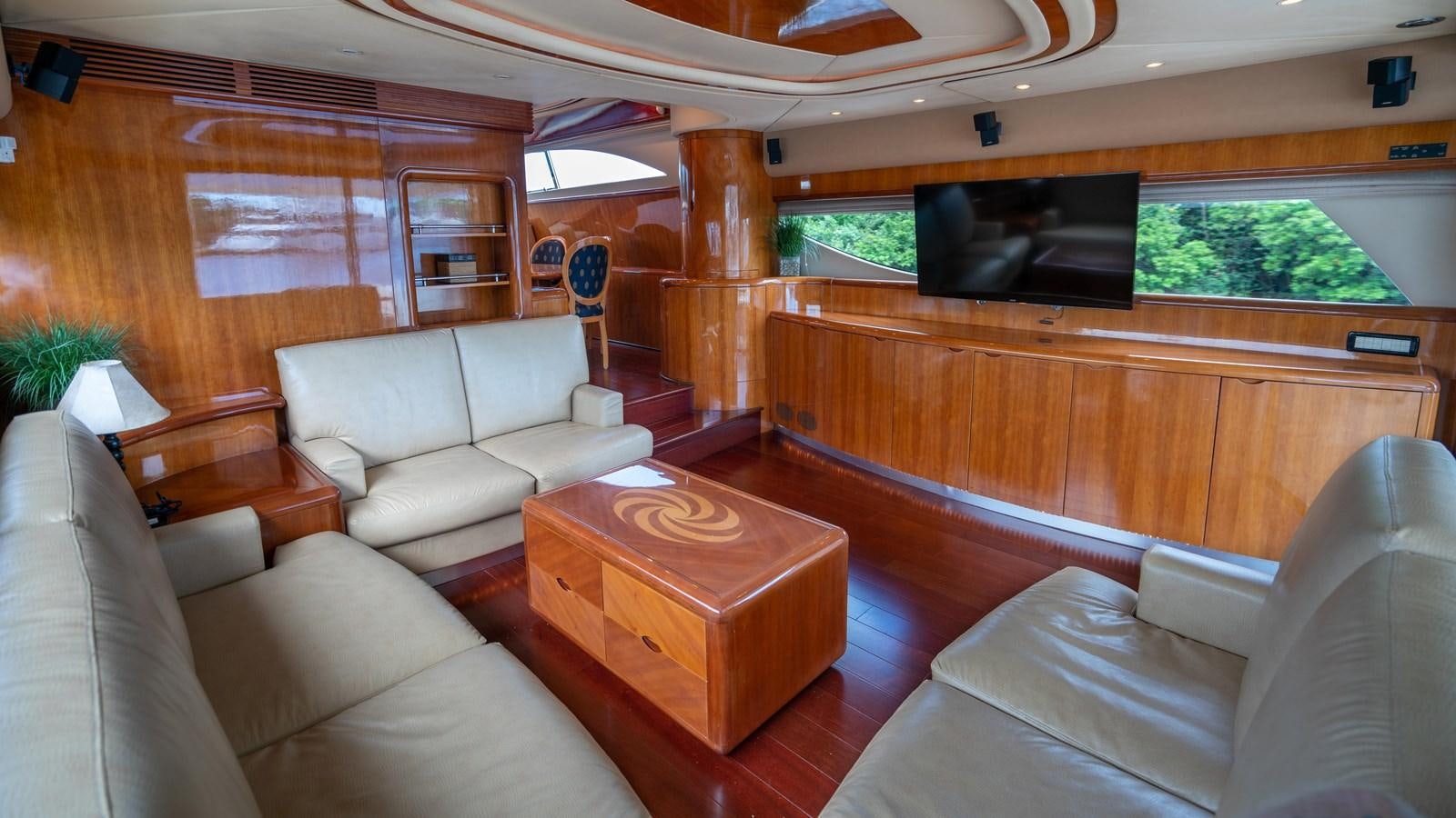 a living room with a wood table aboard FOOLISH PLEASURE Yacht for Sale