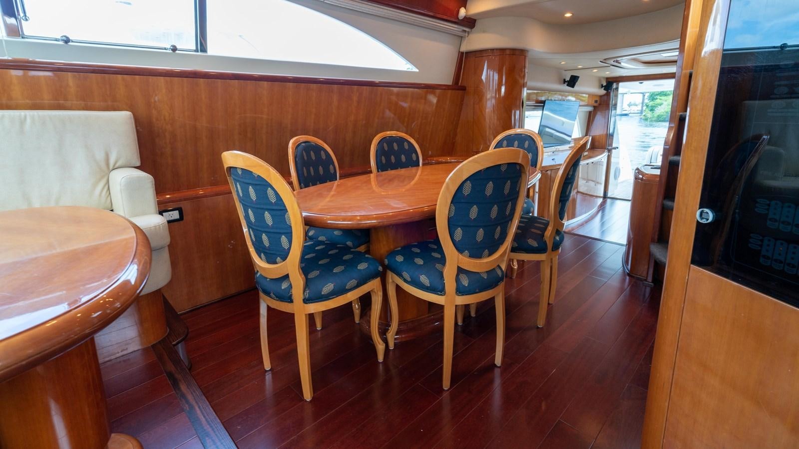 a dining table and chairs in a room aboard FOOLISH PLEASURE Yacht for Sale