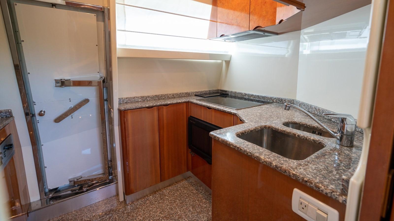 a kitchen with a sink and a refrigerator aboard FOOLISH PLEASURE Yacht for Sale