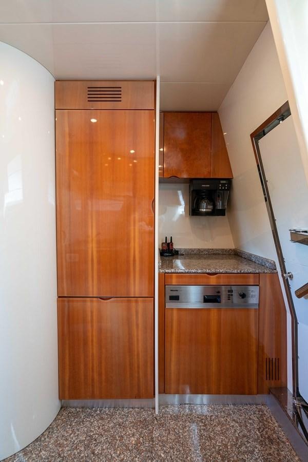 a kitchen with wooden cabinets aboard FOOLISH PLEASURE Yacht for Sale