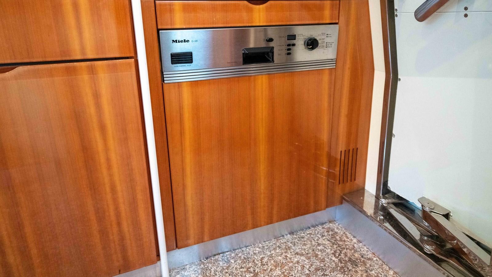 a kitchen with wooden cabinets aboard FOOLISH PLEASURE Yacht for Sale