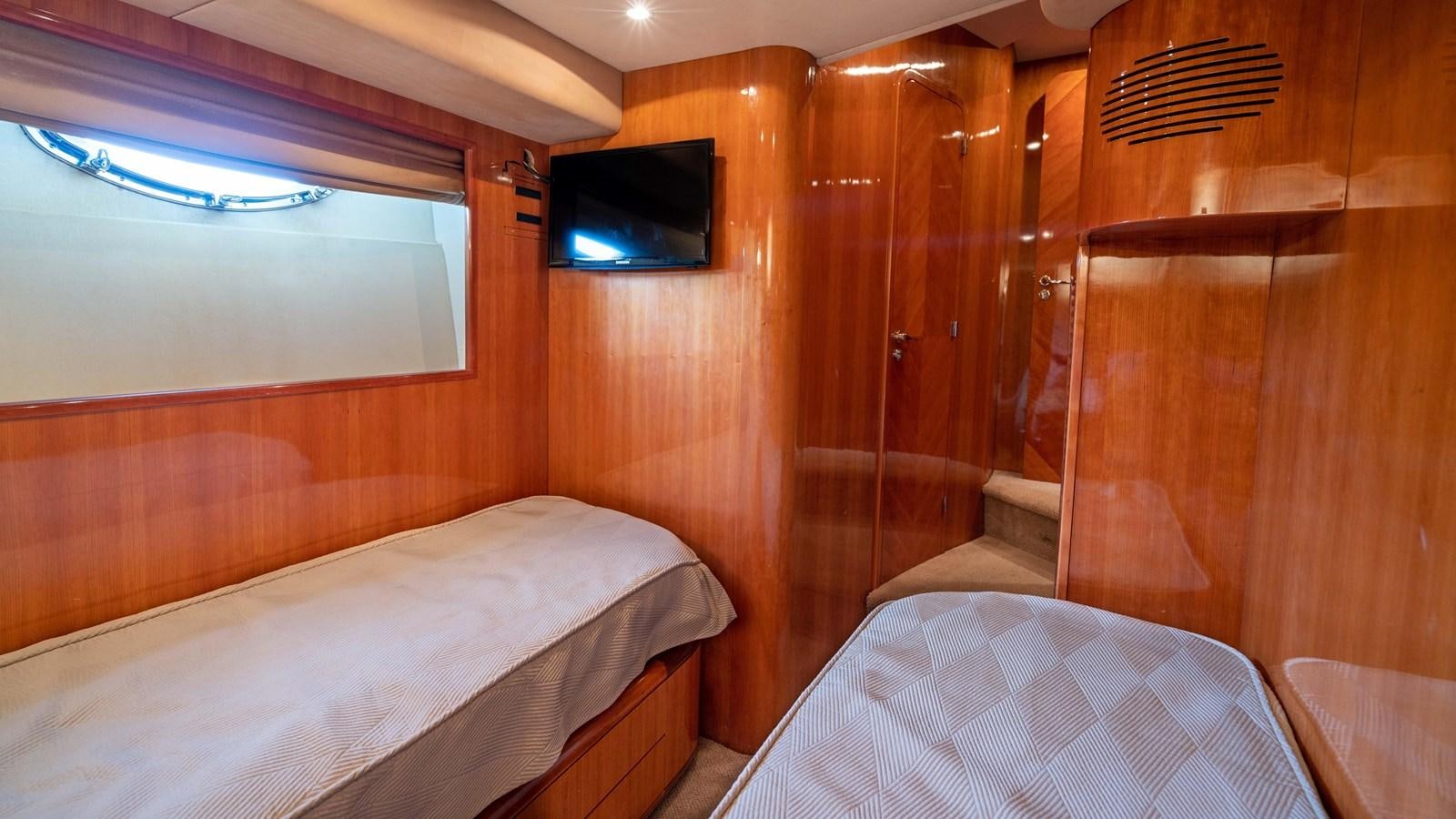 a room with a bed and a television aboard FOOLISH PLEASURE Yacht for Sale