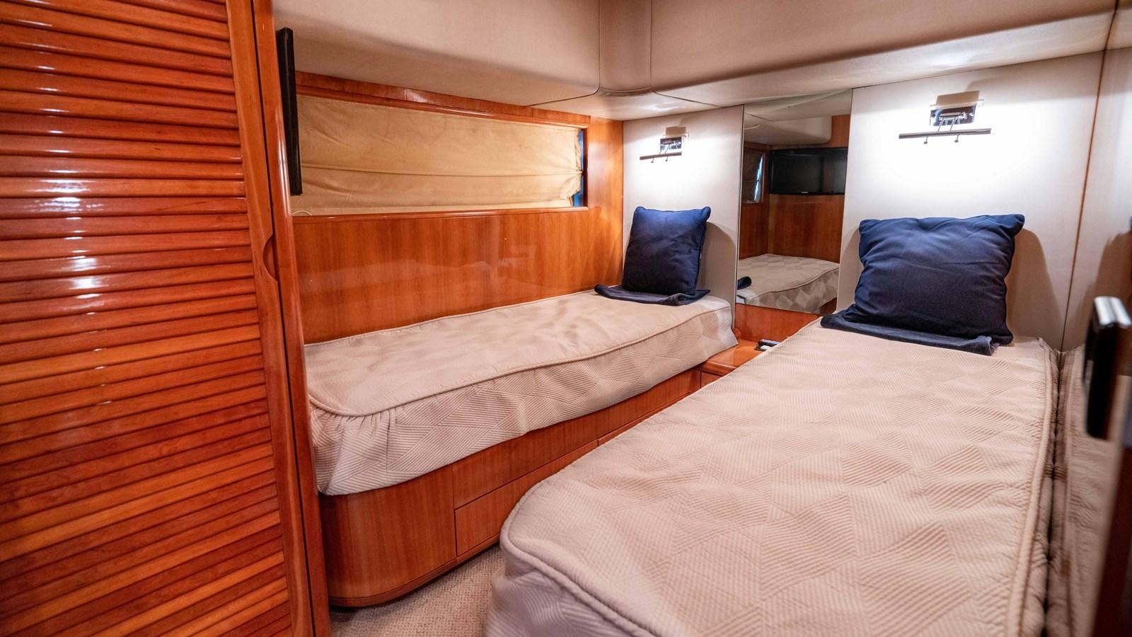 a room with beds and a window aboard FOOLISH PLEASURE Yacht for Sale