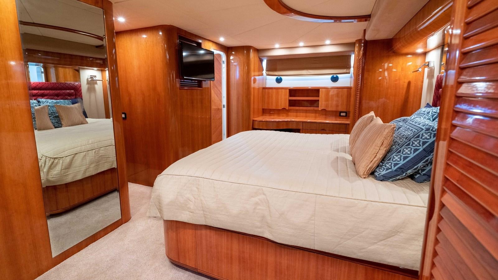 a room with a bed and a wood door aboard FOOLISH PLEASURE Yacht for Sale