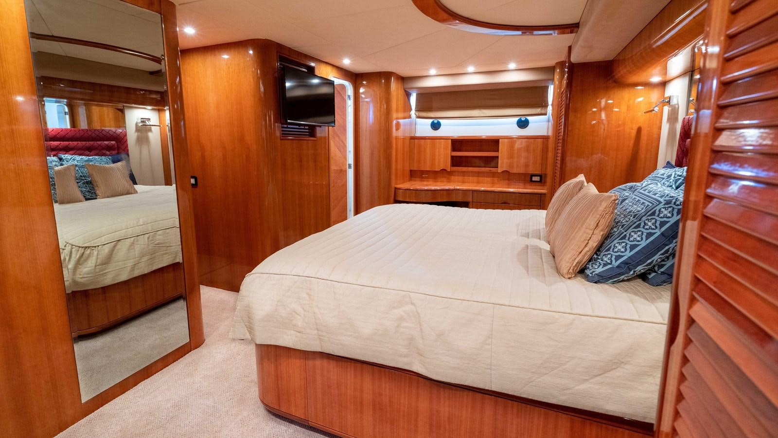 a room with a bed and a wood door aboard FOOLISH PLEASURE Yacht for Sale