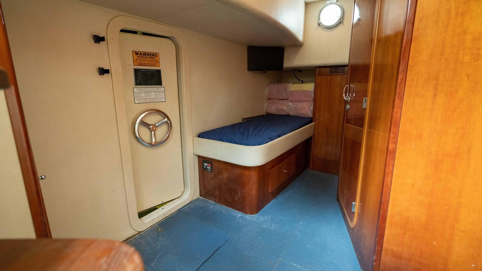 a room with a bed and a desk aboard FOOLISH PLEASURE Yacht for Sale