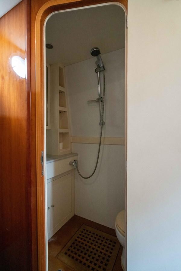 a bathroom with a shower and a toilet aboard FOOLISH PLEASURE Yacht for Sale