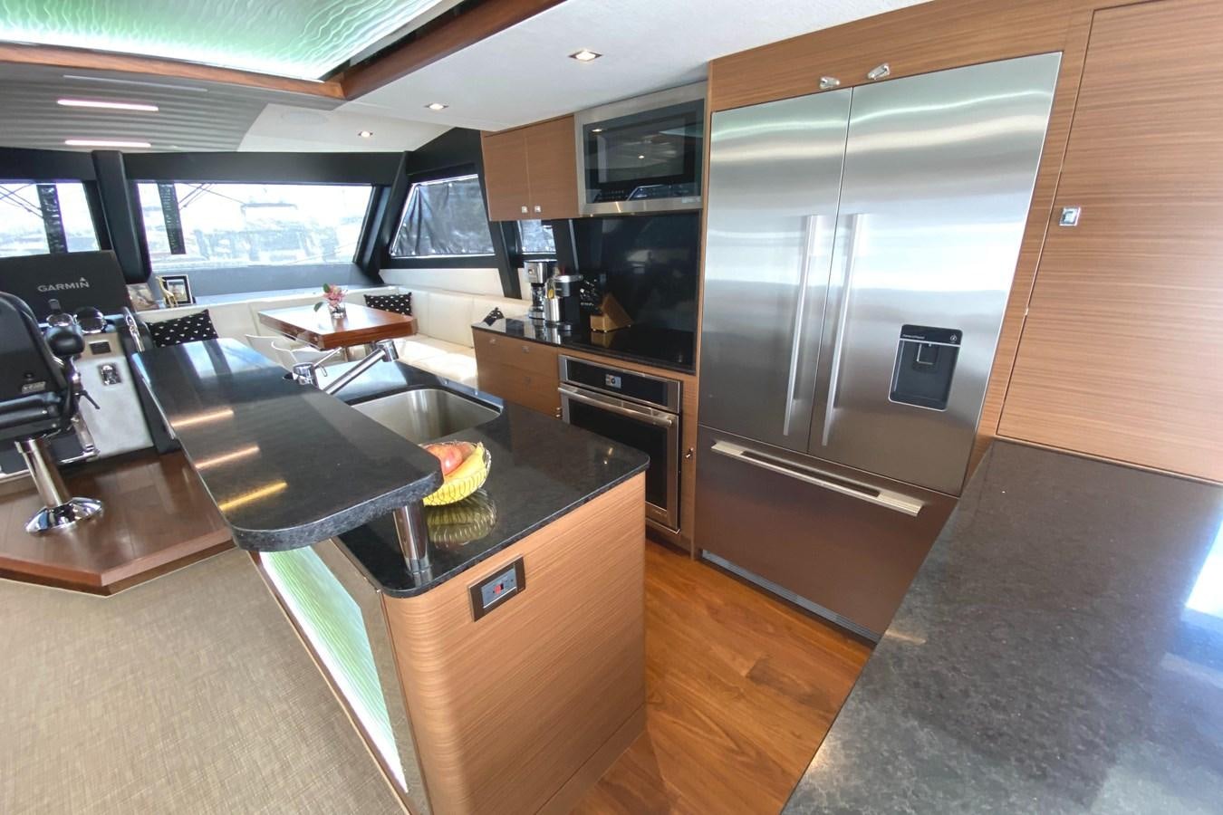 a kitchen with a stainless steel refrigerator aboard PLAYBOOK Yacht for Sale