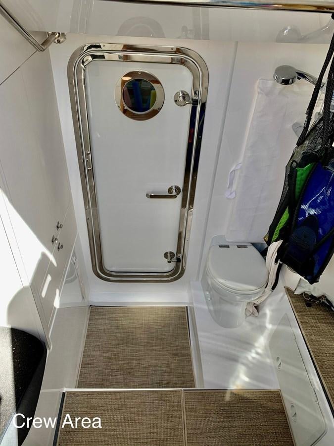 a toilet with a large metal door aboard PLAYBOOK Yacht for Sale