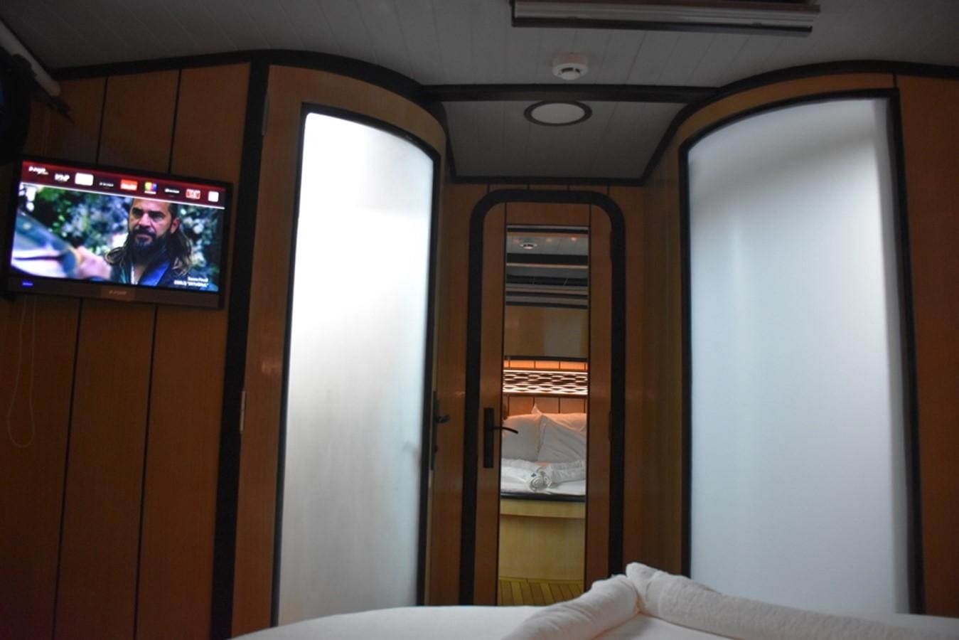 a room with a tv and a bed aboard NOSTALGIA Yacht for Sale