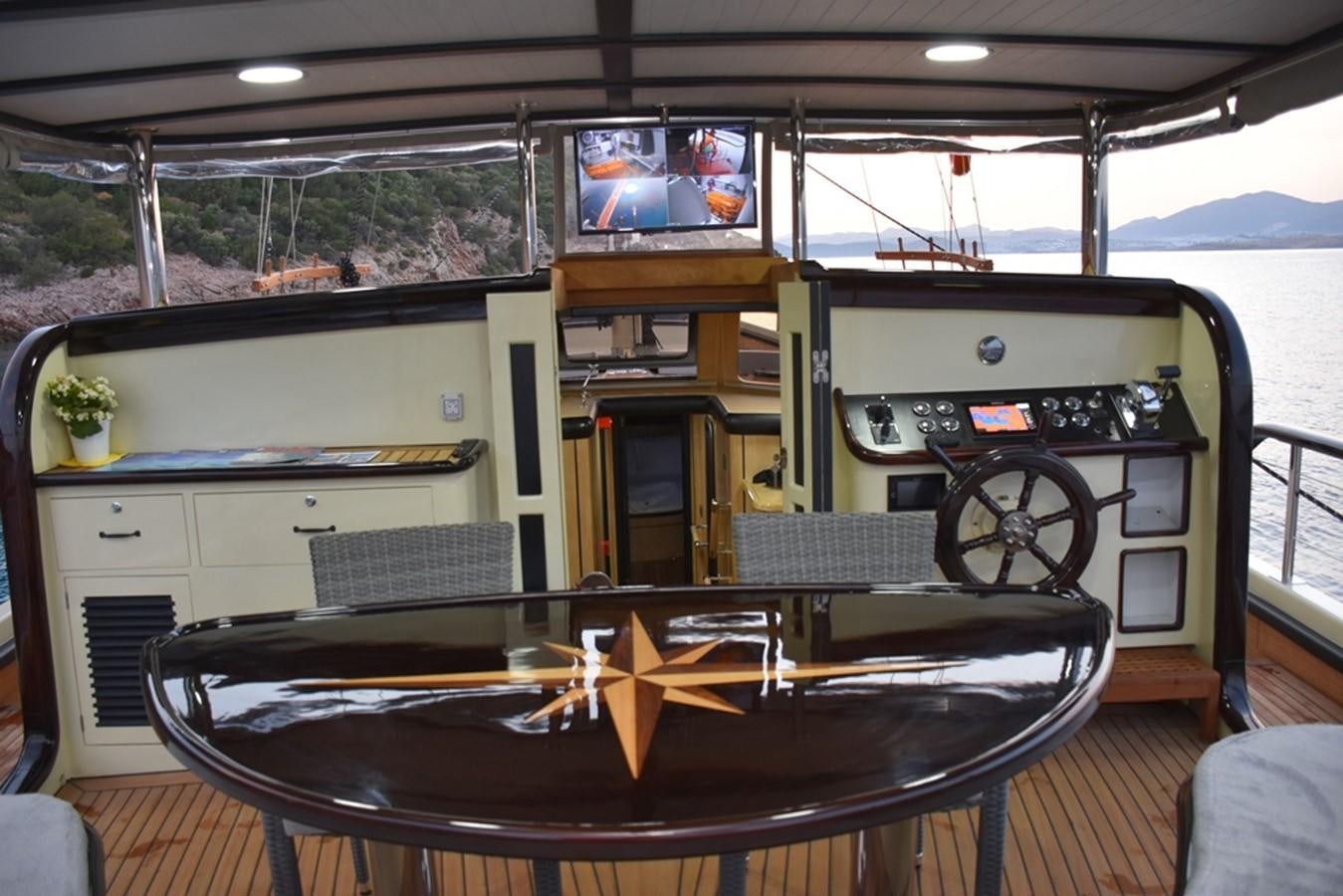 a boat with a table and tv aboard NOSTALGIA Yacht for Sale