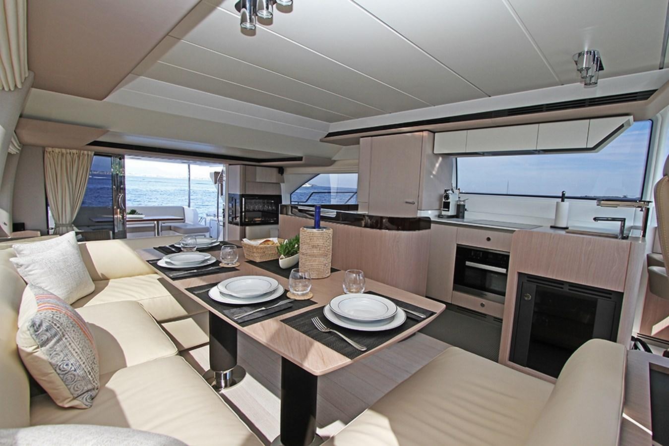 a kitchen with a table and chairs aboard IMAGINE Yacht for Sale