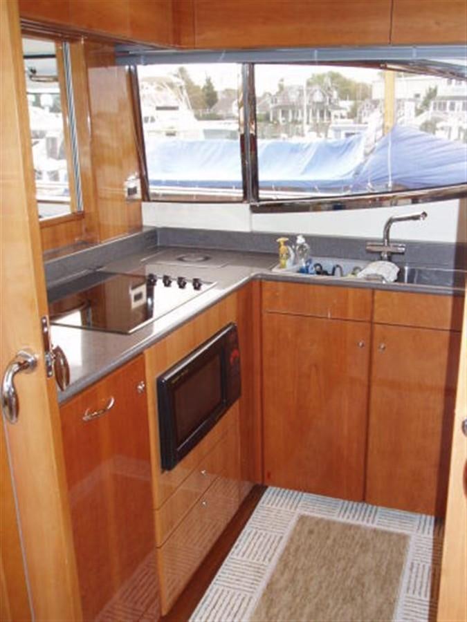 a kitchen with wooden cabinets aboard FOREVER SUMMER Yacht for Sale