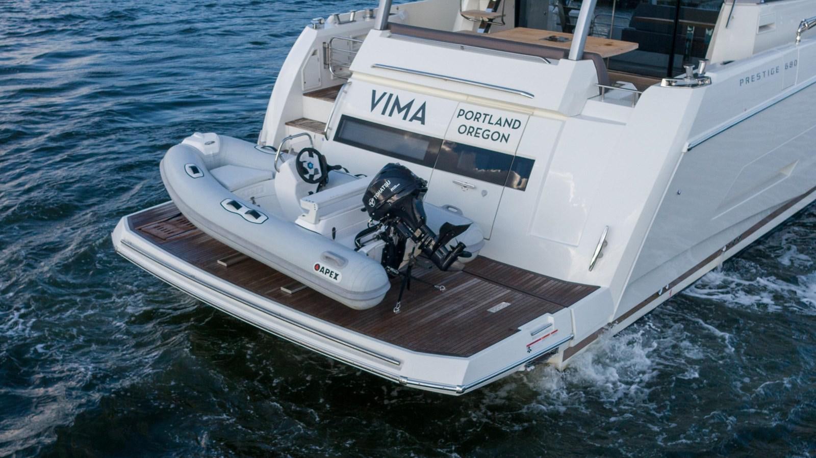 a white boat with a person in it aboard VIMA Yacht for Sale