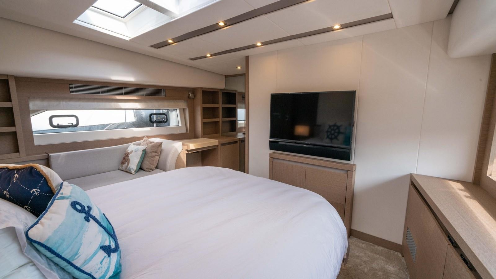 a bedroom with a bed and a television aboard VIMA Yacht for Sale