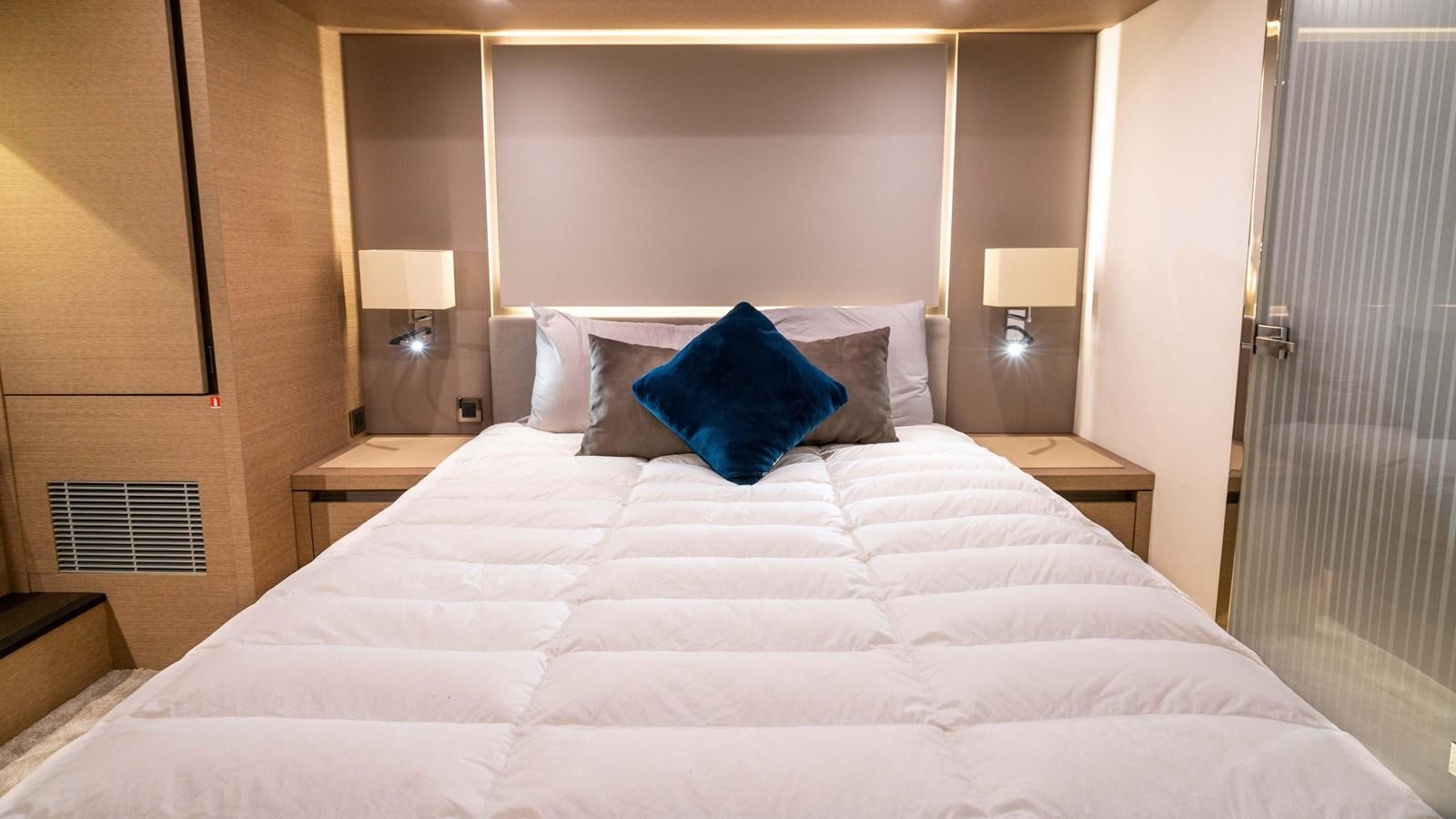 a bed with a white sheet and pillows aboard VIMA Yacht for Sale