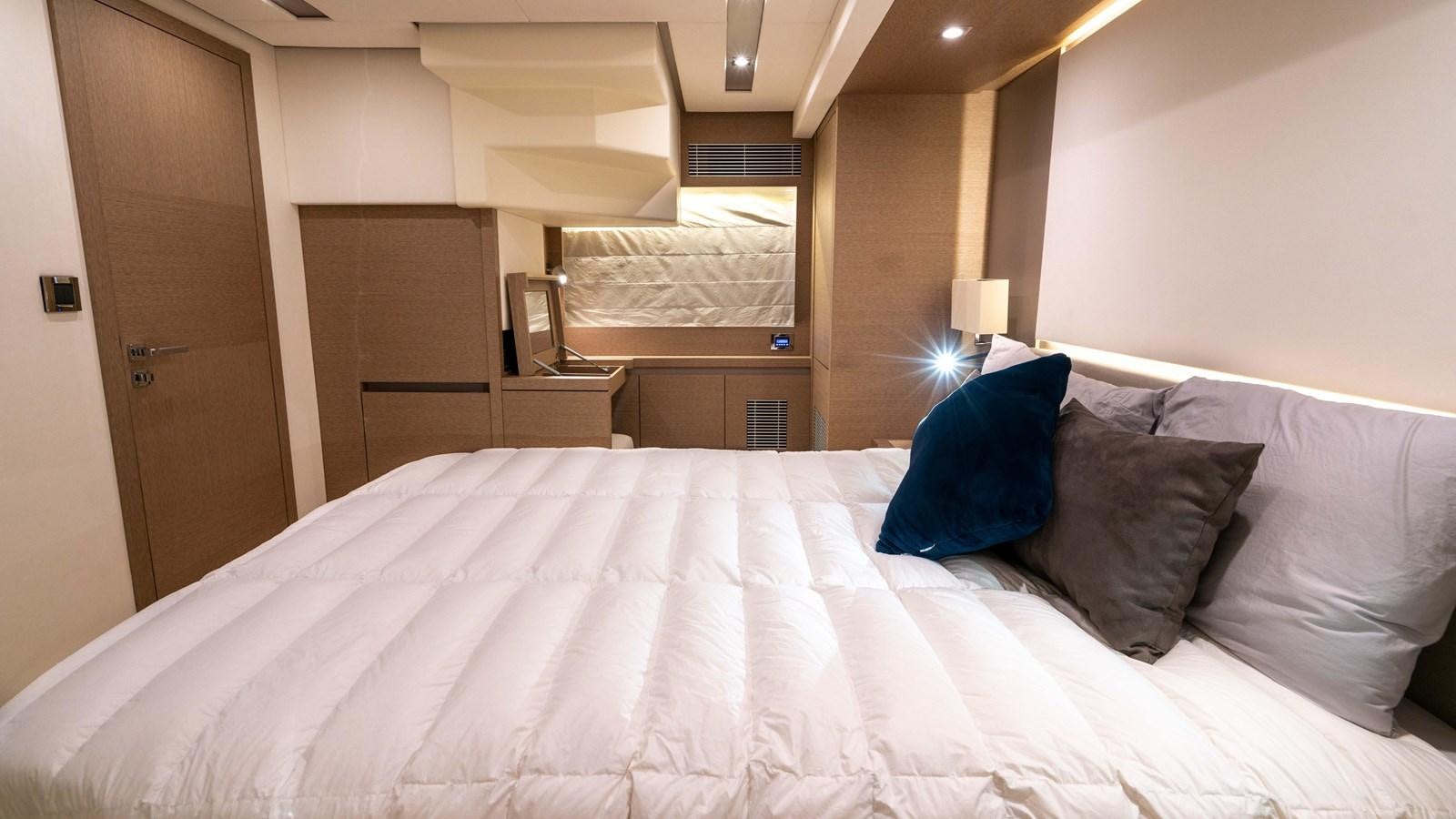 a bed with a white sheet and pillows aboard VIMA Yacht for Sale