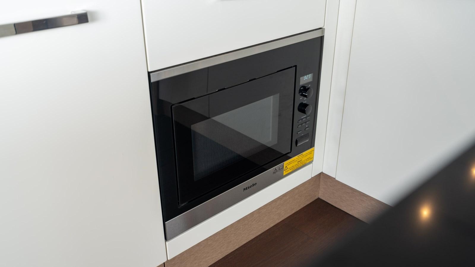 a microwave oven on a white wall aboard VIMA Yacht for Sale