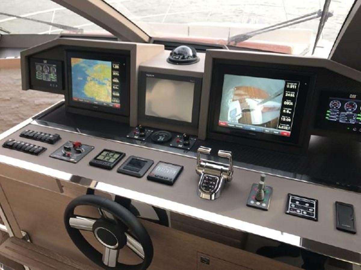 a group of computer screens on a table aboard 2021 ASTONDOA 66 FLYBRIDGE Yacht for Sale