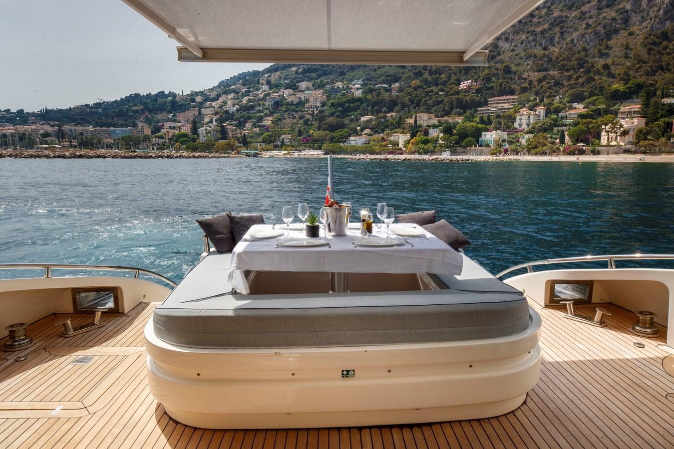 a deck with a bar and a view of a city aboard KOKAB Yacht for Charter